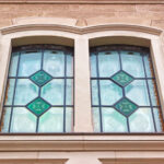 Outside view of a double window with green stained glass features